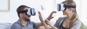Happy young couple wearing virtual reality glasses indoor